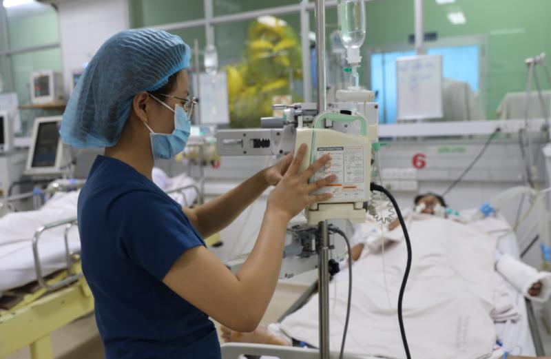 Nhân viên y tế điều chỉnh dịch truyền cho một bệnh nhân sốt xuất huyết nặng tại Bệnh viện Bệnh Nhiệt đới TP HCM, ngày 28/6. Ảnh: Quỳnh Trần