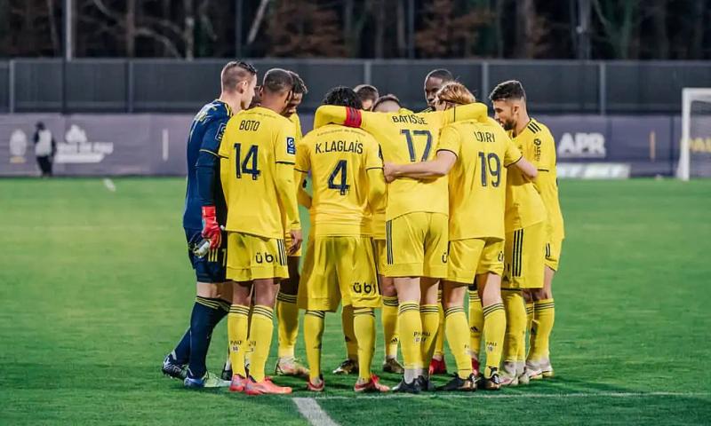 Cầu thủ Pau họp đội trước trận, trên sân Nouste Camp mùa 2021-2022. Ảnh: PauFC