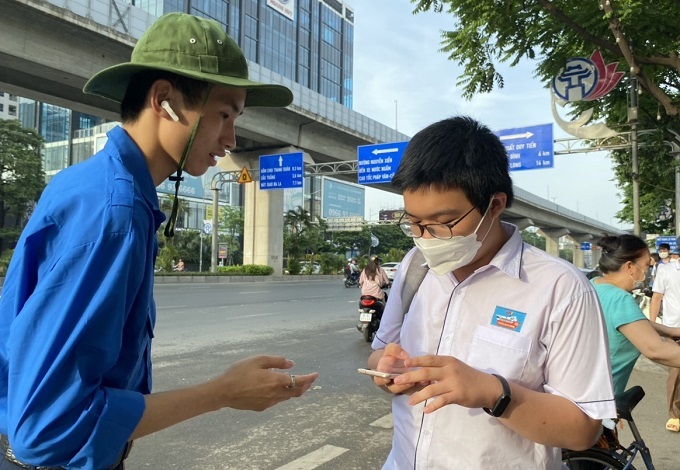 Thí sinh dự thi vào THPT chuyên Khoa học Tự nhiên sáng 5/6 được sinh viên tình nguyện hướng dẫn vào phòng thi. Ảnh: Bình Minh