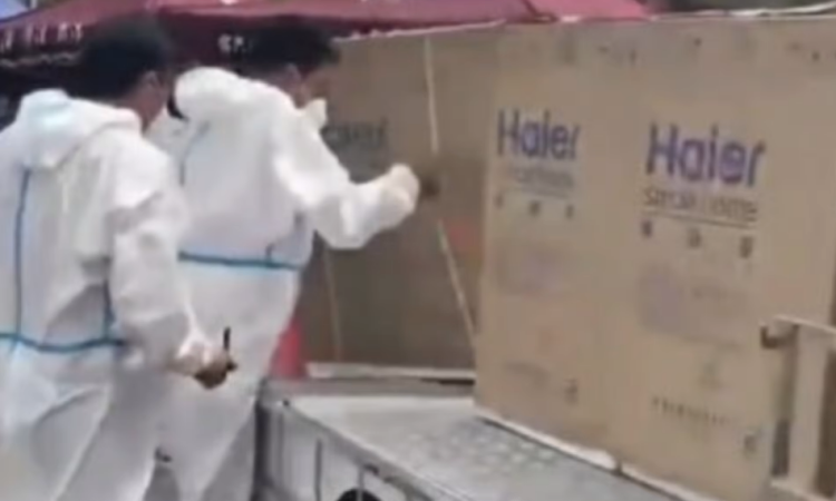 Nhân viên chống dịch mặc đồ bảo hộ hỗ trợ chuyển tủ lạnh cho cư dân Thượng Hải, Trung Quốc, hôm 10/4. Ảnh: Weibo.