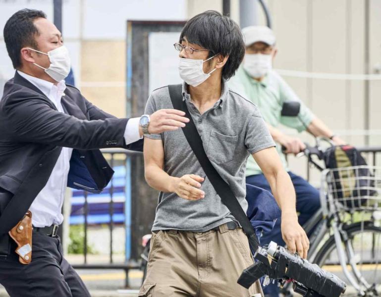 Nghi phạm Tetsuya Yamagami (phải) cầm khẩu súng tự chế khi bị nhân viên an ninh tiếp cận để khống chế sau vụ ám sát ông Abe ở Nara, Nhật Bản ngày 8/7. Ảnh: Kyodo.