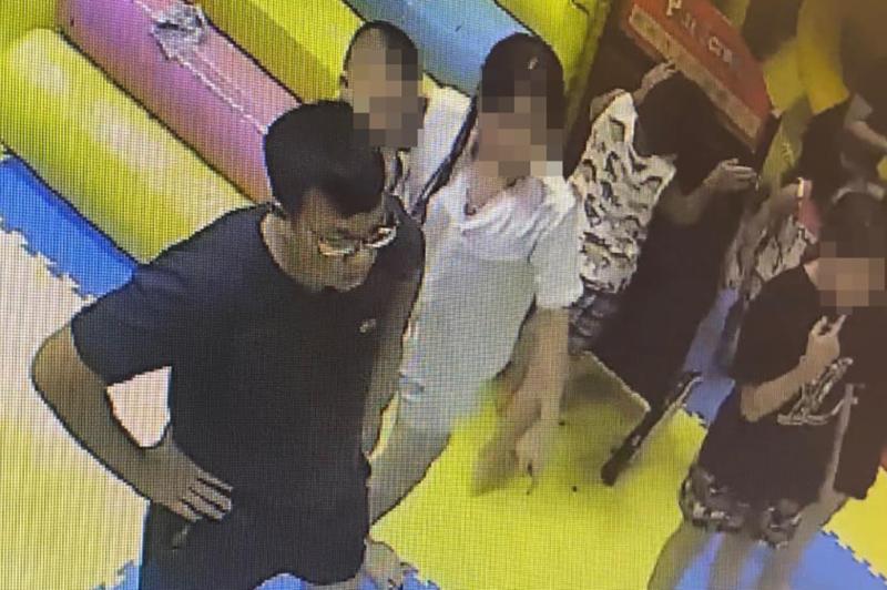 Vũ Trọng Đam (đứng trống tay, mặc áo đen) ở khu vui chơi bị camera an ninh ghi lại. Ảnh: Cắt từ video