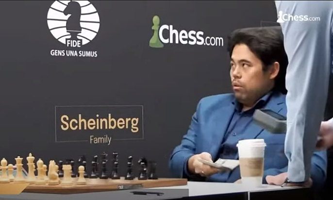 Hikaru Nakamura khi phải đưa ví ra để dò kim loại trước ván đấu Richard Rapport ở Candidates 2022 tại Madrid, Tây Ban Nha. Ảnh: chụp màn hình