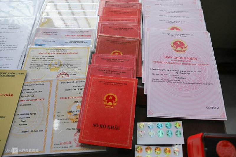 Sổ đỏ, sổ hộ khẩu và các loại bằng cấp giả trong đường dây làm giả giấy tờ, bị Công an Đà Nẵng triệt phá tháng 6/2020. Ảnh:Nguyễn Đông