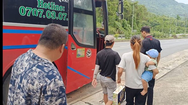 2 vợ chồng anh Duy cùng con nhỏ (ngoài cùng, bên phải) phản ánh bị quỵt lương phải đi bộ về quê được hỗ trợ bắt xe khách. Ảnh: Công an Đà Nẵng cung cấp