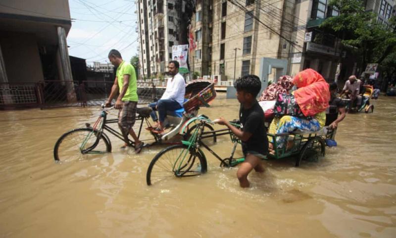 Người dân di chuyển qua con phố ngập nước ở Sylhe, Bangladesh tuần này. Ảnh: AFP.