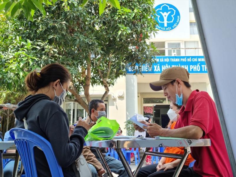 Người lao động ngồi chờ gọi đến lượt vào làm thủ tục nhận BHXH một lần. Ảnh: Nam Dương