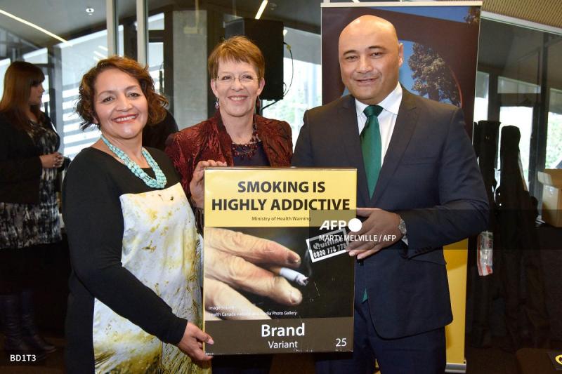 Các quan chức New Zealand cầm mẫu bao thuốc lá trơn mới trong sự kiện giới thiệu nhằm áp dụng bao bì đơn giản trên các sản phẩm thuốc lá năm 2016. Ảnh: AFP
